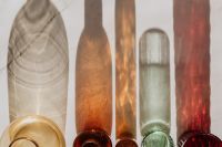 Kaboompics - Colored Glass Bottle Bases and Long Shadows, Close-Up