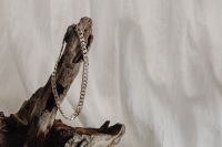Kaboompics - Silver Link Necklace Hanging from Driftwood with Linen Copy Space