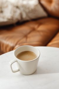 Kaboompics - Close-Up Coffee on White Marble with Soft-Focus Leather Sofa, Warm Interior Background