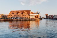 Kaboompics - Gdańsk City Sign and Historic Brick Waterfront Buildings Reflected in the Motława River