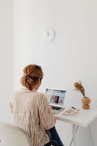 Kaboompics - Woman Working from Home at Laptop with Wall Clock and Copy Space