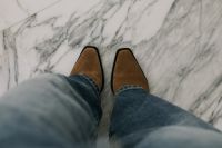 Kaboompics - POV of Tan Suede Ankle Boots and Jeans on a Marble Floor