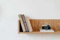 Kaboompics - Design Books and Vintage Film Camera on Floating Wood Shelf