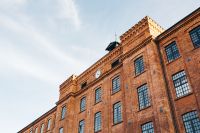 Kaboompics - Angled View of Brick Facade with Rooftop Clock Against Sky