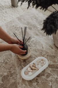 Kaboompics - Hands Arranging Reed Diffuser Sticks on a Marble Table