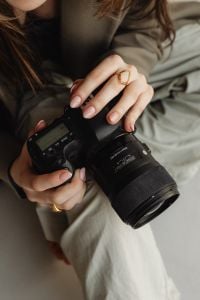 Kaboompics - Young Female Photographer Holding DSLR Camera with Gold Rings