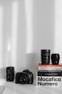 Photographer's desk - books, DSLR camera and lenses