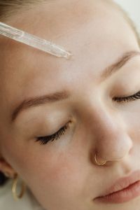 Kaboompics - Extreme Close-Up of Serum Dropper Touching the Forehead During Skincare