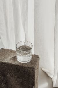 Kaboompics - Single Tumbler of Water Against Sheer White Curtains