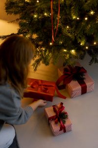 Kaboompics - Gift Wrapping Table with Red Ribbons and Tree Lights