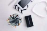 Kaboompics - Top-Down Colored Pencil Jar with Smartphone and Geometric Notebook in Soft Focus, Creative Desk Flat Lay