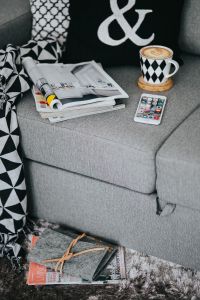 Kaboompics - Open Magazine, Coffee Cup and Smartphone in a Cozy Sofa Scene