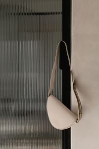 Kaboompics - White Leather Shoulder Bag by Ribbed Glass Door