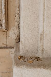 Kaboompics - Gold and Silver Rings with a Delicate Chain on a Textured Stone Ledge, Copy Space