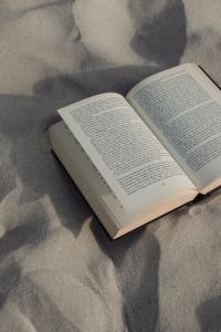 Kaboompics - Open Book Casting a Long Shadow on Fine Beach Sand