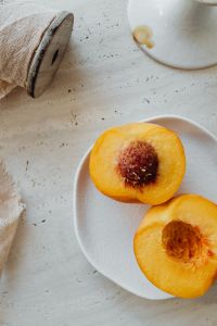 Kaboompics - Close-Up of Peach Halves on Plate with Soft Copy Space