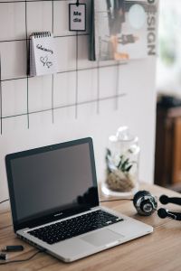 MacBook Pro with headphones on a wooden desk