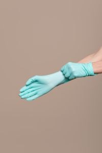 Woman hands putting on a latex gloves