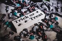 Kaboompics - Overhead Halloween Treat Sign and Wrapped Candy Flat Lay on Dark Cloth