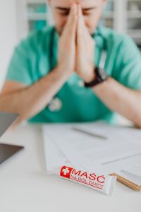 Kaboompics - Doctor Holding Ointment Tube Above Documents