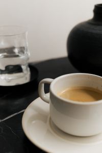 Kaboompics - Close Up of White Coffee Cup and Water Glass on Black Slate Table