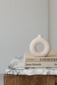 Kaboompics - Minimalist Ceramic Ring Vase and Art Books against a Soft Neutral Wall