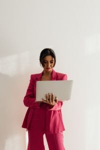 Kaboompics - Asian Businesswoman Holding Laptop in Pink Satin Suit