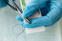 Kaboompics - Gloved Hands Opening a Dental Suture Packet