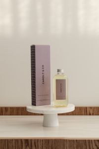 Kaboompics - White Lotus Fragrance Bottle and Box on a Round Pedestal