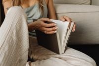 Kaboompics - Woman Reading a Book on the Sofa in a Cozy Home