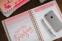 Kaboompics - Pink Floral Desk Calendar with Silver Smartphone and White Pen, Wooden Table Flat Lay