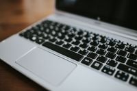 Kaboompics - Angled Close-Up of Silver Laptop Keyboard and Touchpad on Wood