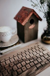 Kaboompics - Wooden Birdhouse on a Desk with Coffee and Keyboard