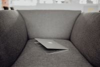 Kaboompics - Close up view of closed laptop lying on grey armchair