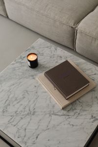 Kaboompics - Lit Candle and Design Books on Marble beside Beige Sofa