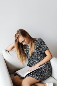 Kaboompics - Teenage Student Reading Textbook in an Armchair at Home