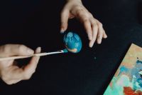 Kaboompics - Woman Painting Blue Easter Eggs