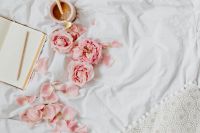 Kaboompics - Open Notebook, Pink Roses and Coffee on White Bedding with Crochet Textile Detail
