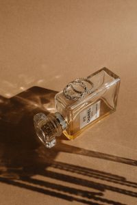 Kaboompics - Perfume Bottle with Cap on a Brown Paper Backdrop