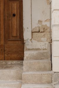 Kaboompics - Old Wooden Door with Black Knob and Weathered Stone Steps