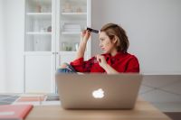 Kaboompics - Side View of Woman Lifting Eyeglasses while Resting Her Forehead beside Laptop