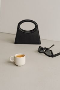 Kaboompics - Close-Up of Black Handbag, Espresso Cup and Sunglasses