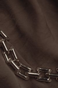 Kaboompics - Silver Jewelry Chain Along the Edge of a Dark Background