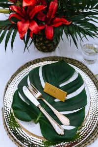 Kaboompics - Red Tropical Flower Arrangement with Monstera Leaves on a Styled Table