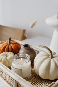 Kaboompics - White Pumpkins and a Scented Candle in a Wicker Tray