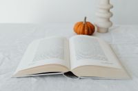 Kaboompics - Open Book, Orange Mini Pumpkin and Sculptural White Vase