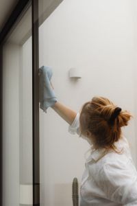 Kaboompics - Woman Wiping a Glass Window in a Modern Home