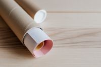 Kaboompics - Kraft Cardboard Tube with Rolled White Paper on Light Wood Background