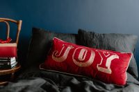 Kaboompics - Joy Pillow on a Dark Textured Bedspread