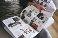 Kaboompics - Woman reading a designer magazine on a couch